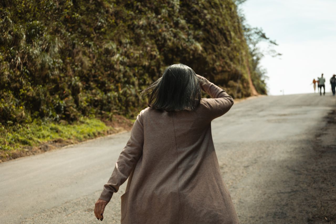 Mulher madura olhando para o horizonte com determinação, refletindo sobre quem você deseja ser daqui para frente.
